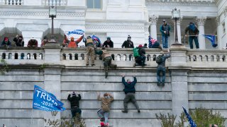 Supporters of President Donald Trump climb the west wall of the the U.S. Capitol on Wednesday, Jan. 6, 2021, in Washington.