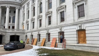 Workers begin boarding up the Wisconsin state Capitol building in Madison on Monday, Jan. 11, 2021. State officials are concerned about the prospects of state-centered violence in the wake of last week's security breaches at the U.S. Capitol.