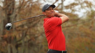 In this Dec. 20, 2020, file photo, Tiger Woods of the United States plays his shot from the ninth tee during the final round of the PNC Championship at the Ritz-Carlton Golf Club Orlando in Orlando, Florida.