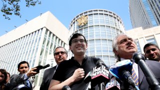 Martin Shkreli, former chief executive officer of Turing Pharmaceuticals AG, center, while his attorney Benjamin Brafman, right, speaks to members of the media outside federal court in the Brooklyn borough of New York, U.S., on Friday, Aug. 4, 2017.