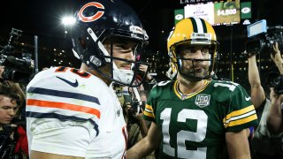 Bears quarterback Mitchell Trubisky, wearing a white jersey and the team's signature navy blue helmet, greets Packers quarterback Aaron Rodgers, who is wearing the Packers' gold helmet and a green jersey, after a 2019 game at Lambeau Field