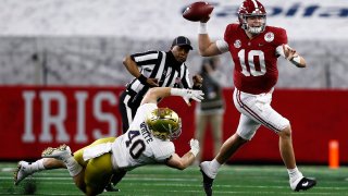 Quarterback Mac Jones #10 of the Alabama Crimson Tide delivers a pass over linebacker Drew White #40 of the Notre Dame Fighting Irish during the first quarter of the 2021 College Football Playoff Semifinal Game at the Rose Bowl Game presented by Capital One at AT&T Stadium on January 01.