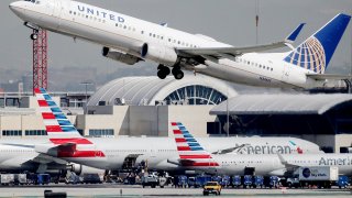 A United Airlines plane takes off above American Airlines planes on the tarmac at Los Angeles International Airport (LAX) on October 1, 2020 in Los Angeles, California.