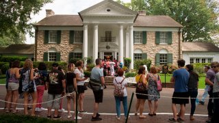 fans wait in line outside Graceland, Elvis Presley's Memphis home, in Memphis, Tenn.