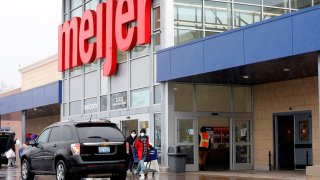 People wear face masks as they leave a Meijer store