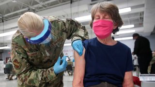 In this Feb. 3, 2021, file photo, Sergeant Jennifer Callender (L) of the Illinois Air National Guard administers a Pfizer Covid-19 vaccine to Virginia Persha at a vaccination center established at the Triton College in River Grove, Illinois.