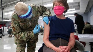 In this Feb. 3, 2021, file photo, Sergeant Jennifer Callender (L) of the Illinois Air National Guard administers a Pfizer Covid-19 vaccine to Virginia Persha at a vaccination center established at the Triton College in River Grove, Illinois.