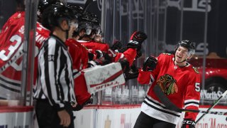 CHICAGO, ILLINOIS – FEBRUARY 11: Ian Mitchell #51 of the Chicago Blackhawks celebrates with teammates on the bench after his goal against the Columbus Blue Jackets in the second period at the United Center on February 11, 2021 in Chicago, Illinois. (Photo by Chase Agnello-Dean/NHLI via Getty Images)