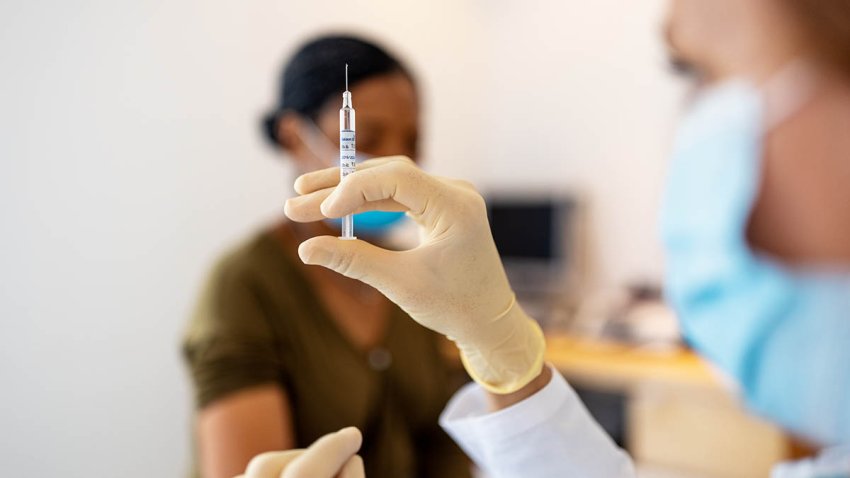 Close up of doctor preparing injection for vaccination in clinic. Hands of a female doctor preparing flu injection.