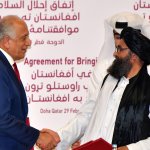 U.S. Special Representative for Afghanistan Reconciliation Zalmay Khalilzad, left, and Taliban co-founder Mullah Abdul Ghani Baradar shake hands after signing a peace agreement during a ceremony in the Qatari capital Doha on Feb. 29, 2020.