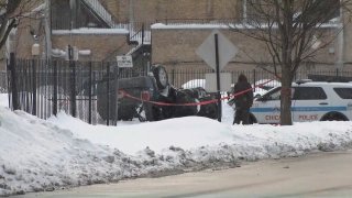 A black vehicle is pictured flipped over after it hit a Chicago police cruiser in the Englewood neighborhood