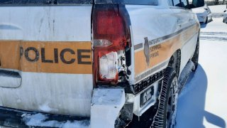An Illinois State Police car, white with a gold stripe across the middle, shows damage to the rear right bumper after being hit on Interstate 55