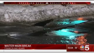 A broken water main spews water onto Adams Street near the Willis Tower on Feb. 17, 2021.