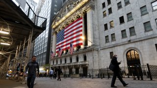 Pedestrians walk past the New York Stock Exchange.