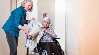 Caregiver assisting elderly woman