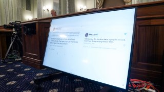 Tweets from President Donald Trump are displayed on a screen