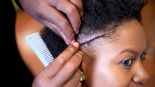 hair stylist braiding woman’s hair