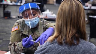 In this Jan. 26, 2021, file photo, SPC Janae Jones of the Illinois Army National Guard administers a COVID-19 vaccine at a mass vaccination center established at the Tinley Park Convention Center in Tinley Park, Illinois.