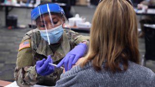 In this Jan. 26, 2021, file photo, SPC Janae Jones of the Illinois Army National Guard administers a COVID-19 vaccine at a mass vaccination center established at the Tinley Park Convention Center in Tinley Park, Illinois.