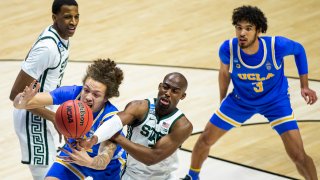 UCLA's Mac Etienne, front left, competes for a rebound with Michigan State's Joshua Langford during the second half of a First Four game in the NCAA men's college basketball tournament, Thursday, March 18, 2021, at Mackey Arena in West Lafayette, Indiana. UCLA won 86-80.