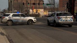 Two Chicago police cars sit in an intersection in Avalon Park after an officer was hurt in an attack during a traffic stop