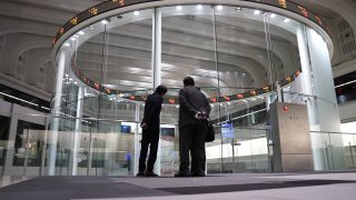 Visitors stands in front of an electronic ticker at the Tokyo Stock Exchange (TSE), operated by Japan Exchange Group Inc. (JPX), in Tokyo, Japan, on Monday, Nov. 30, 2020.