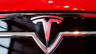 A Tesla logo on a Model S is photographed inside of a Tesla dealership in New York.
