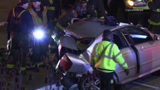 Chicago police examine the mangled remains of a gray car after a fatal crash on the Dan Ryan Expressway