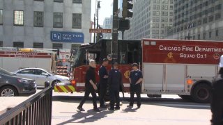 Chicago firefighters stand near a fire truck after a rescue effort was launched Sunday near the Chicago River