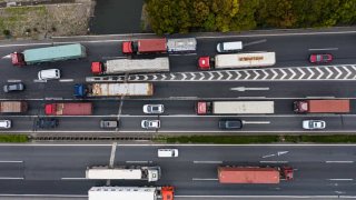 Freight trucks and other vehicles travel on a highway in this aerial photograph taken in Shanghai, China, on Wednesday, March 25, 2020. Full Truck Alliance or Manbang looks to connect truck drivers to those looking to ship goods.