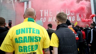 A fan wears a shirt with a "United Against Greed" message, as fans gather to protest against the Glazer family, the owners of Manchester United, outside Old Trafford stadium