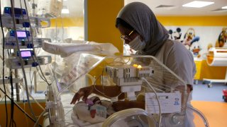 A Moroccan nurse takes care of one of the nine babies protected in an incubator at the maternity ward of the private clinic of Ain Borja in Casablanca, Morocco, Wednesday, May 5, 2021. A Malian woman gave birth to nine babies after n ' to have waited only seven, announced Wednesday the Ministry of Health of Mali. . Halima CissÈ, 25, gave birth by caesarean section Tuesday in Morocco after being sent there for special care, the ministry said.