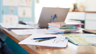 Colored pencils and school books on dining table