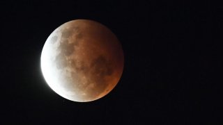 The full moon is seen during the partial eclipse in Sydney on May 26, 2021 as stargazers across the Pacific are casting their eyes skyward to witness a rare “Super Blood Moon”. (Photo by Saeed KHAN / AFP) (Photo by SAEED KHAN/AFP via Getty Images)