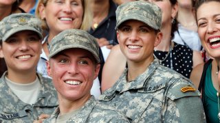 Army 1st Lt. Shaye Haver, center, and Capt. Kristen Griest, right, pose for photos with other female West Point alumni after an Army Ranger school graduation ceremony