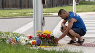 A man brings flowers and pays his respects at the scene where a man driving a pickup truck struck and killed four members of a Muslim family in London, Ontario, Canada on June 7, 2021.