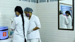 Health care workers prepare a dose of COVID-19 coronavirus vaccine, at a vaccination centre in Guwahati, Assam, India on 18 June 2021.