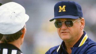 UNSPECIFIED – CIRCA 1986: Head Coach Bo Schembechler of the Michigan Wolverines talks with an official while his team warms up before the start of an NCAA football game circa 1986. Schembechler coached the Wolverines from 1969-89. (Photo by Focus on Sport/Getty Images)