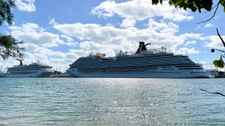 The cruise ships “Carnival Sunrise” (L) and “Carnival Vista” (R) part of the Carnival Cruise Line, are seen moored at a quay in the port of Miami, Florida, on December 23, 2020, amid the Coronavirus pandemic.