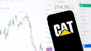 Caterpillar Inc. logo seen displayed on a smartphone with the stock market information of Caterpillar Inc. in the background.