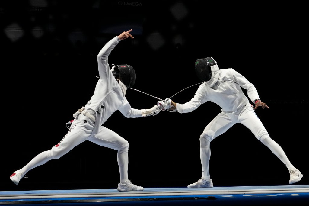 Kazuyasu Minobe of Japan, left, and Yeisser Ramirez of the United States compete in the men's Epee team round of 16