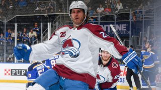 Brandon Saad, wearing a white, blue and burgundy Avalanche jersey, spreads his arms in celebration of a goal against the St. Louis Blues
