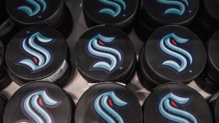 Hockey pucks with the Seattle Kraken's stylized green and red S logo are seen in a file photo