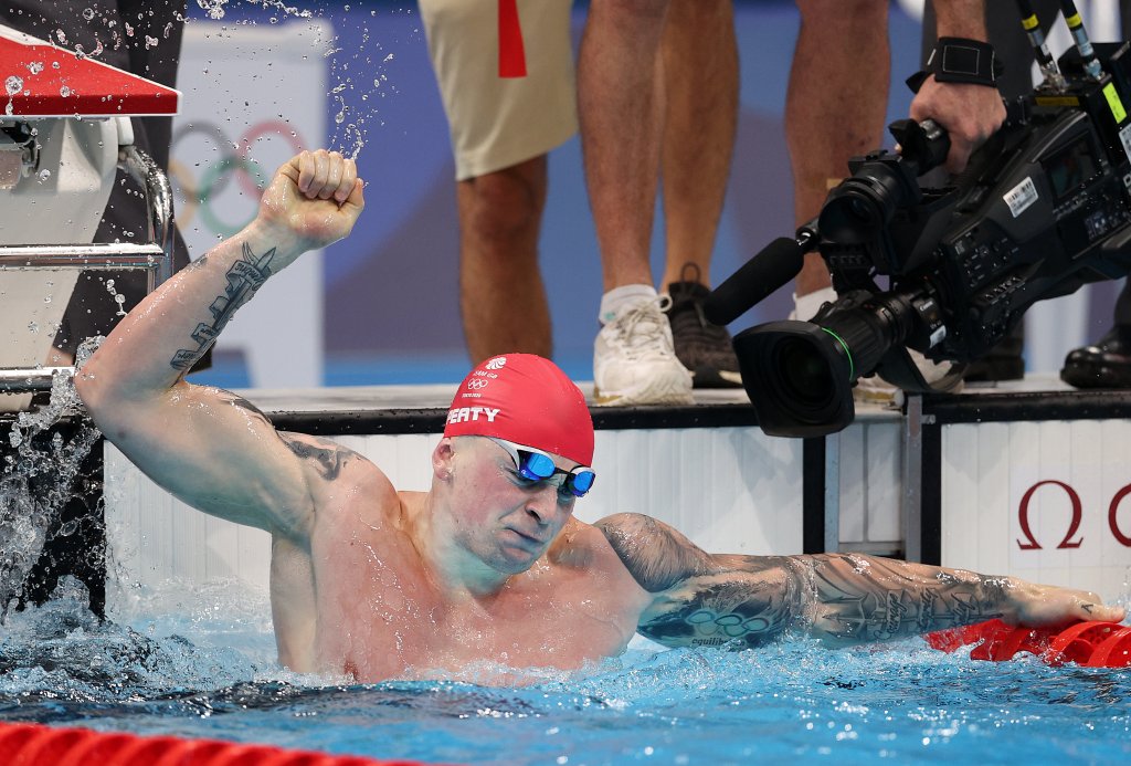 Adam Peaty of Team Great Britain celebrates after winning the gold medal in the Men's 100m Breaststroke Final on day three of the Tokyo 2020 Olympic Games at Tokyo Aquatics Centre on July 26, 2021 in Tokyo, Japan.