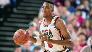 Scottie Pippen is seen in a red, white and blue Team USA jersey and shorts, dribbling a ball during the 1992 Olympics in Spain