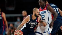 France's Evan Fournier (10) drives past United States' Jrue Holiday (12) during Men's Basketball gold medal game at the 2020 Olympics, Saturday, Aug. 7, 2021, in Saitama, Japan.