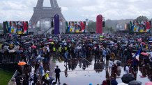 People watch the closing ceremony of the Tokyo 2020 Olympic Games on giant screens in the Olympics fan zone at Trocadero Gardens in front of the Eiffel Tower in Paris, Sunday, Aug. 8, 2021. A giant flag will be unfurled on the Eiffel Tower in Paris Sunday as part of the handover ceremony of Tokyo 2020 to Paris 2024, as Paris will be the next Summer Games host in 2024. The passing of the hosting baton will be split between the Olympic Stadium in Tokyo and a public party and concert in Paris.