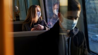 commuters wearing masks aboard public transportation