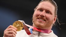 Gold medallist USA's Ryan Crouser poses on the podium after the men's shot put event during the Tokyo 2020 Olympic Games at the Olympic stadium in Tokyo on Aug. 5, 2021.