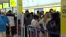 Travelers at Fort Lauderdale International Airport wait in line amid dozens of Spirit Airlines cancelations